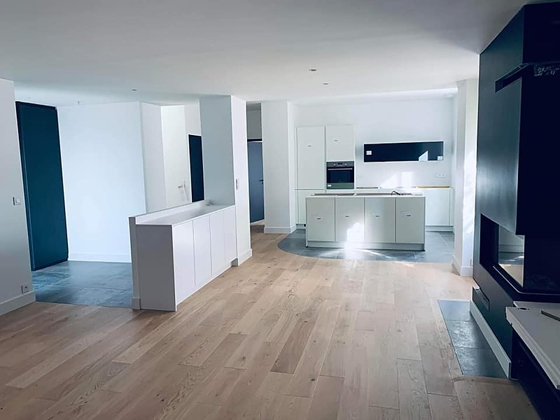 Parquet chêne avec encadrement de cheminée et arrondi épousant le carrelage de cuisine, pose sur mesure à Quimper.